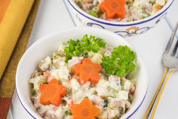 Traditional russian olivier salad with ham vegetables.