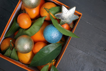 Мандарины и новогодние игрушки в оранжевой коробке  - obrazy, fototapety, plakaty
