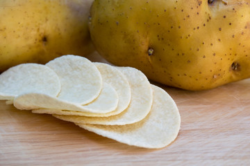 potato chips and potatoes on wooden table
