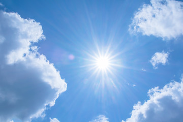 Naklejka na ściany i meble Realistic shining sun with lens flare on blue sky clouds nature day sky background