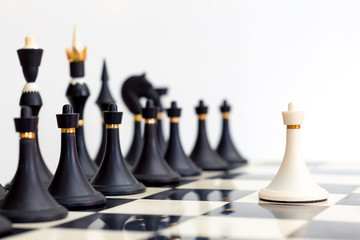 white pawn standing in front of the black pieces