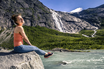 Young woman relaxing and enjoying the view on the fjord of Norwa