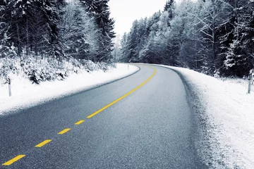 Fototapeten Empty country road in snowy forest in winter  © BOOCYS