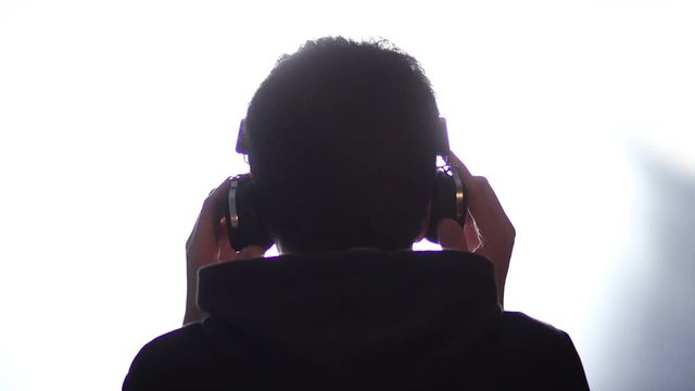 Back view of a man listening music with headphones