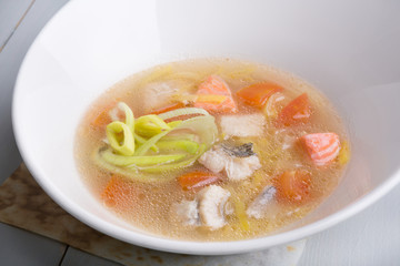 Fish soup in a white bowl