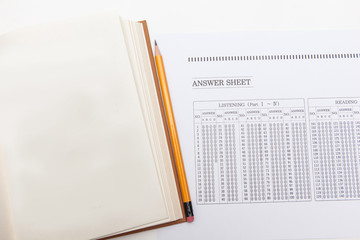 crumpled omr answer sheet and books on white backgrounds