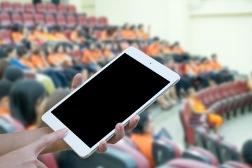 Hands woman holding touch screen smart phone,tablet on blurred .audience at the conference hall background.