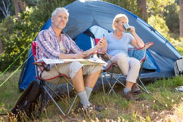 Senior couple relaxing beside their tent © WavebreakMediaMicro