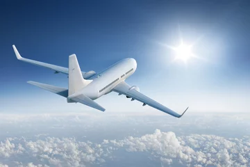 Abwaschbare Fototapete Flugzeug Verkehrsflugzeug fliegt der Sonne am blauen Himmel entgegen
