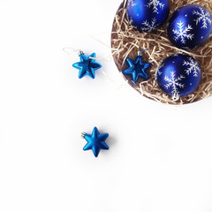 round box with bright blue christmas balls on white background. flat lay, top view