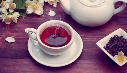 Hot black tea in a cup and saucer, vintage toning