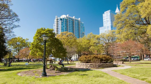 Moore Square Park in Downtown Raleigh North Carolina with Green Trees in Spring Season and Skyscrapers into a Blue Sky Background