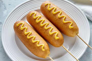 Corn dog traditional American corndog street junk food hotdog meat sausage with mustard snack treat...