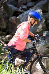 senior woman is walking with her bike