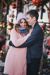 Happy couple in warm clothes posing on a Christmas market. Holiday mood