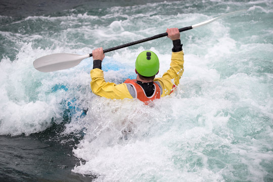 Kayaker holding his paddle above his head