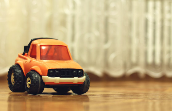 Old worn toy car in the house