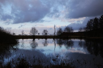 Seenlandschaft mit Wolken am Abend - 128496727