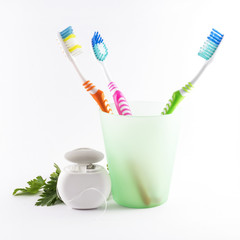 Toothbrushes and dental floss on white background