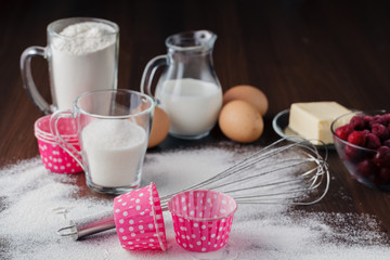 Muffin ingredients: the frozen cherry in a plate, eggs, flour on