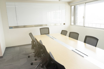 wooden table in meeting room white board sunlight from window