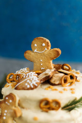 A cake decorated in the Christmas theme with some gingerbread (close-up