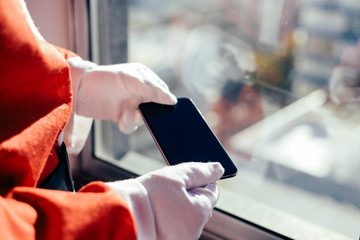 Santa Claus working at desk and using apps on a touch screen tablet