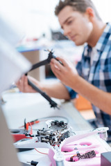Handsome man repairing drone detail