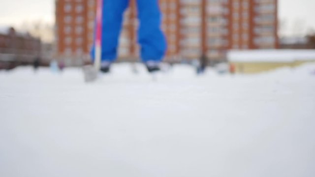 Hockey Player Skating Towards Camera At Low Angle On Skates And Doing A Turn Cutting Ice To Powder