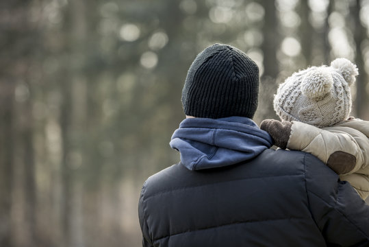 Parent holding a young child on a winter day