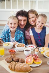 Portrait of family smiling while having breakfast