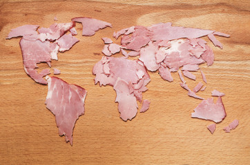 World map made from meat slices on wooden background