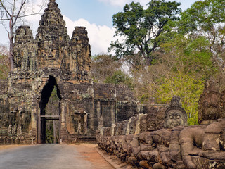 South gate to Angkor Thom and the faces of stone giants guarding the entrance, Cambodia.