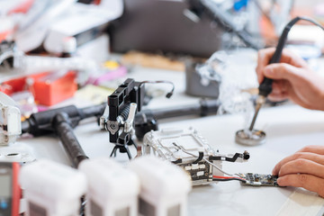 Fototapeta na wymiar Close up of mans hands soldering drone mechanism