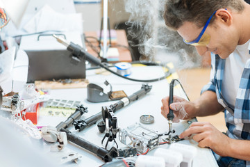 Smiling man soldering drone details