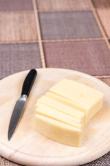 Sliced yellow pizza cheese on the wooden cutting board