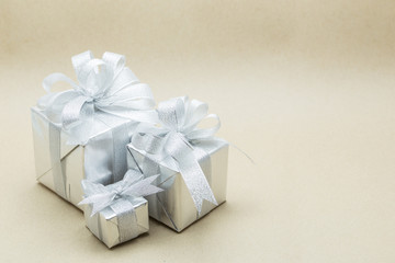 Silver gift box on brown paper background