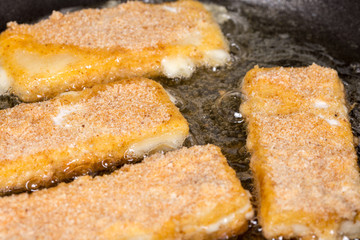 Frying fried yellow cheese with eggs in frying pan