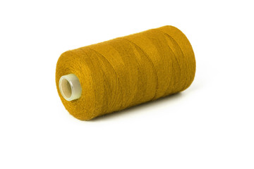 Fototapeta na wymiar Still life of a dark yellow spool of thread on a white background - Closeup Detail