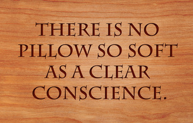 There is no pillow so soft as a clear conscience - French Proverb on wooden red oak background