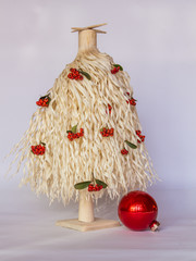 White wood shavings Christmas tree with red berries and one big red ornament