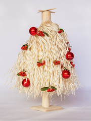 white Christmas tree made of wood shavings with red and green ball ornaments 