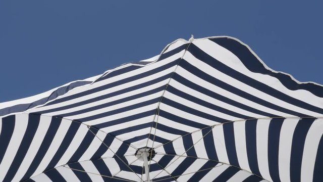 
Striped fabric of umbrella made for protection from the sun 4K 2160p 30fps UltraHD footage - Beach blue parasaol with hypnotic effect 3840X2160 UHD video