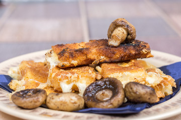 Fried mushroom with fried yellow cheese on eggs