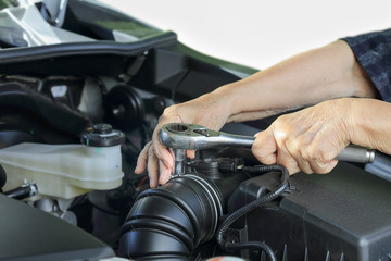Fototapeta na wymiar Elderly woman repairing her car