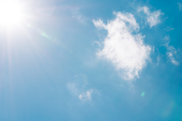 Naklejka na ściany i meble Realistic shining sun with lens flare on blue sky clouds nature day sky background
