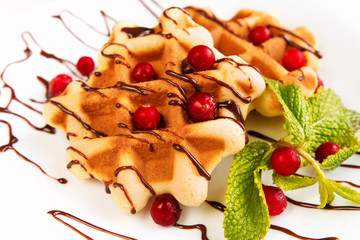 Dessert waffles with cranberries and chocolate syrup