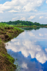 Fototapeta premium Clouds reflected in the river Mologa
