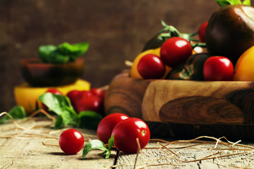 Various tomatoes on old wooden table, selective focus