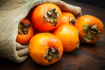 Delicious fresh persimmon fruit on wooden table